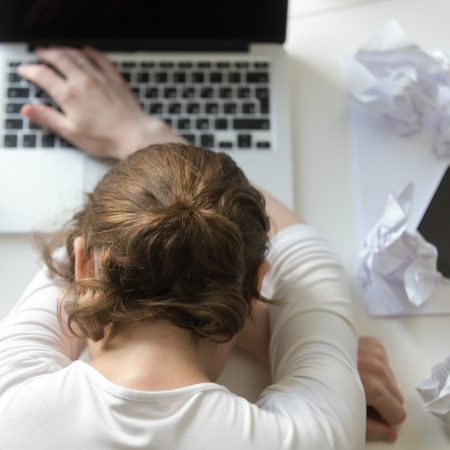 Top view portrait of a woman lying at the desk near the laptop. Education, business concept photo. Lifestyle
